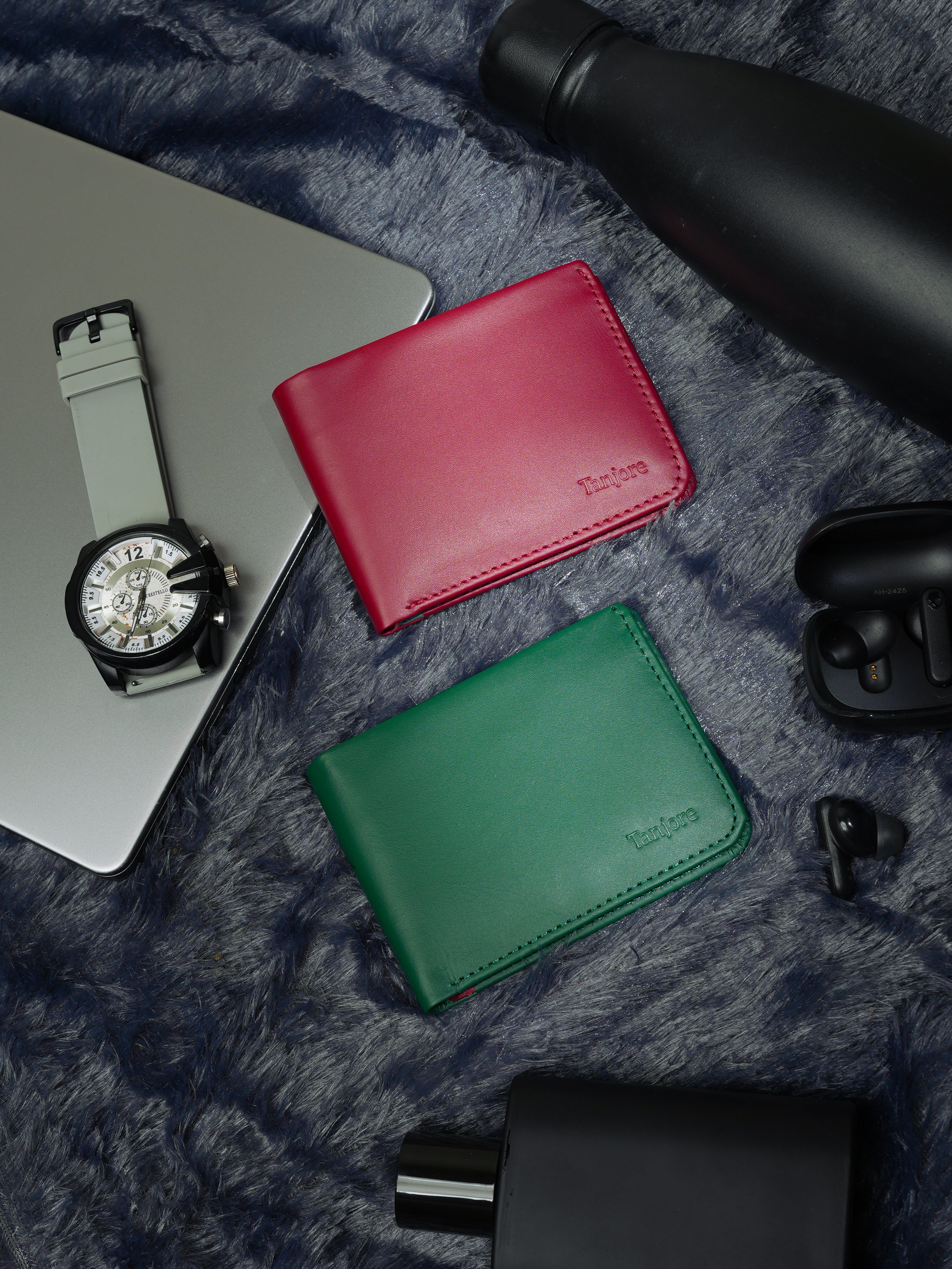 Tanjore Modern Classic 2.0 wallets in Plum and Green styled with a laptop, smartwatch, and earbuds. Modern RFID secure bifolds designed for the digital age.