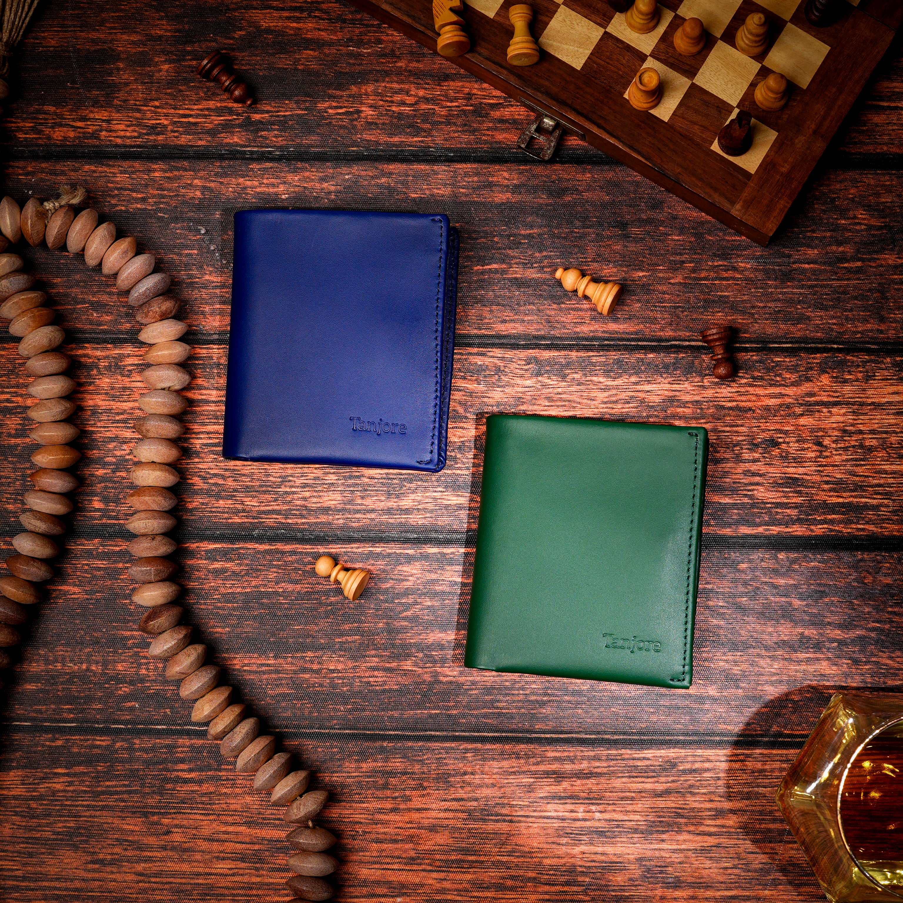 Elegant display of Tanjore Reserve Sleeves in Navy and Green on dark wood. Full Grain Nappa Leather wallets with a Slim Profile, ideal for gifting.