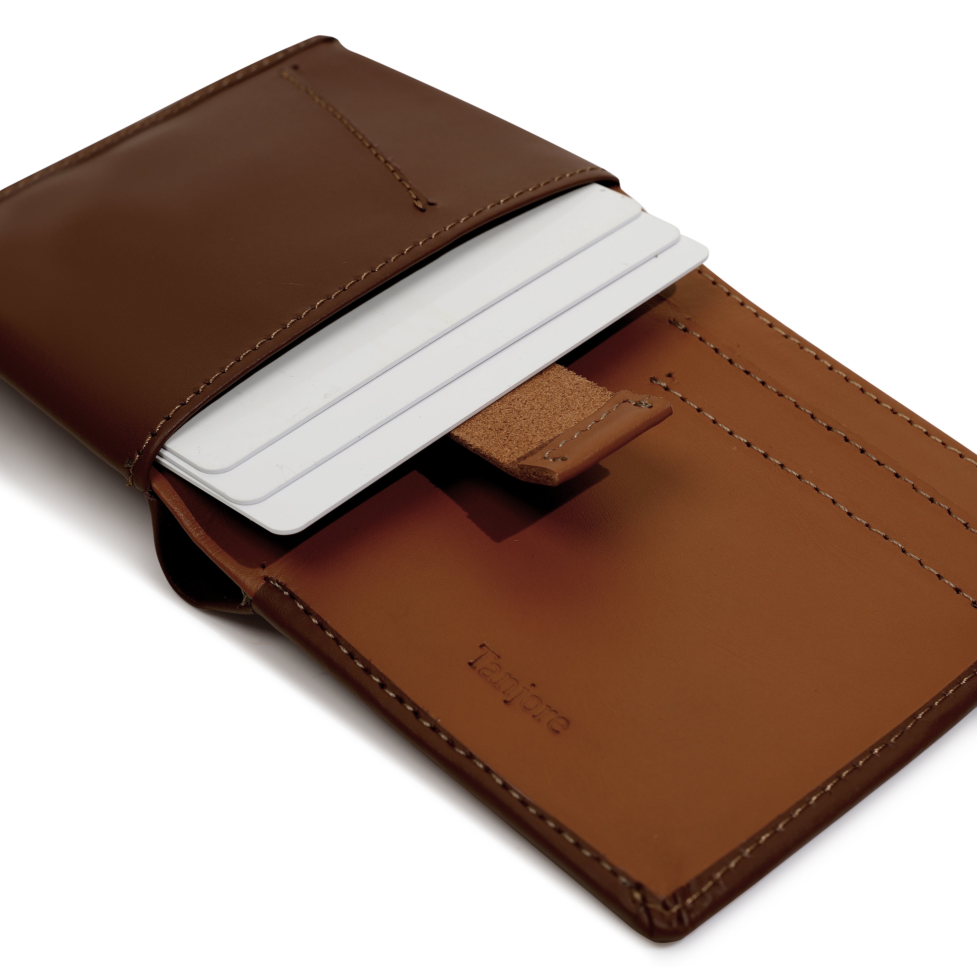 Close-up of the Tan Pull Tab mechanism in the Tanjore Reserve Sleeve. The Brown leather design allows quick card access while maintaining a Slim Profile