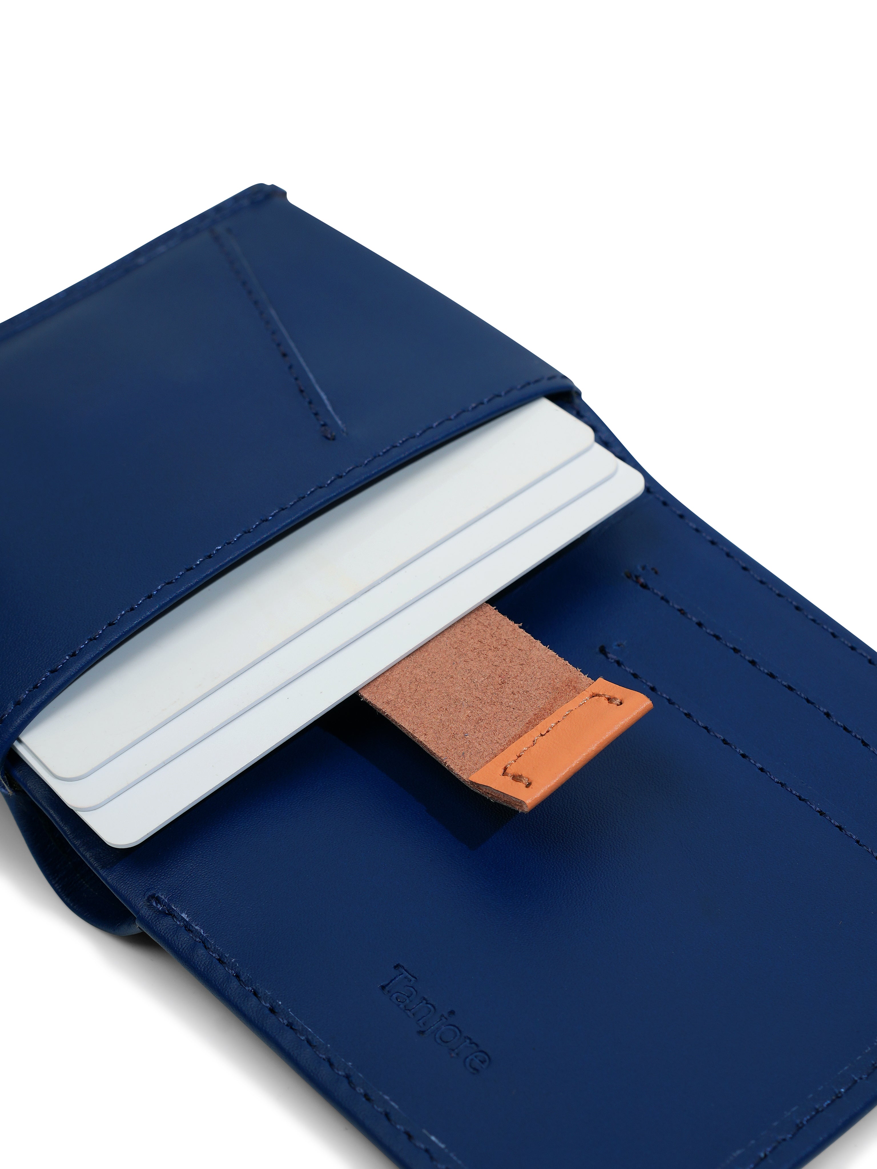 Close-up of the Tan Pull Tab mechanism in the Tanjore Reserve Sleeve. The Navy leather design allows quick card access while maintaining a Slim Profile.