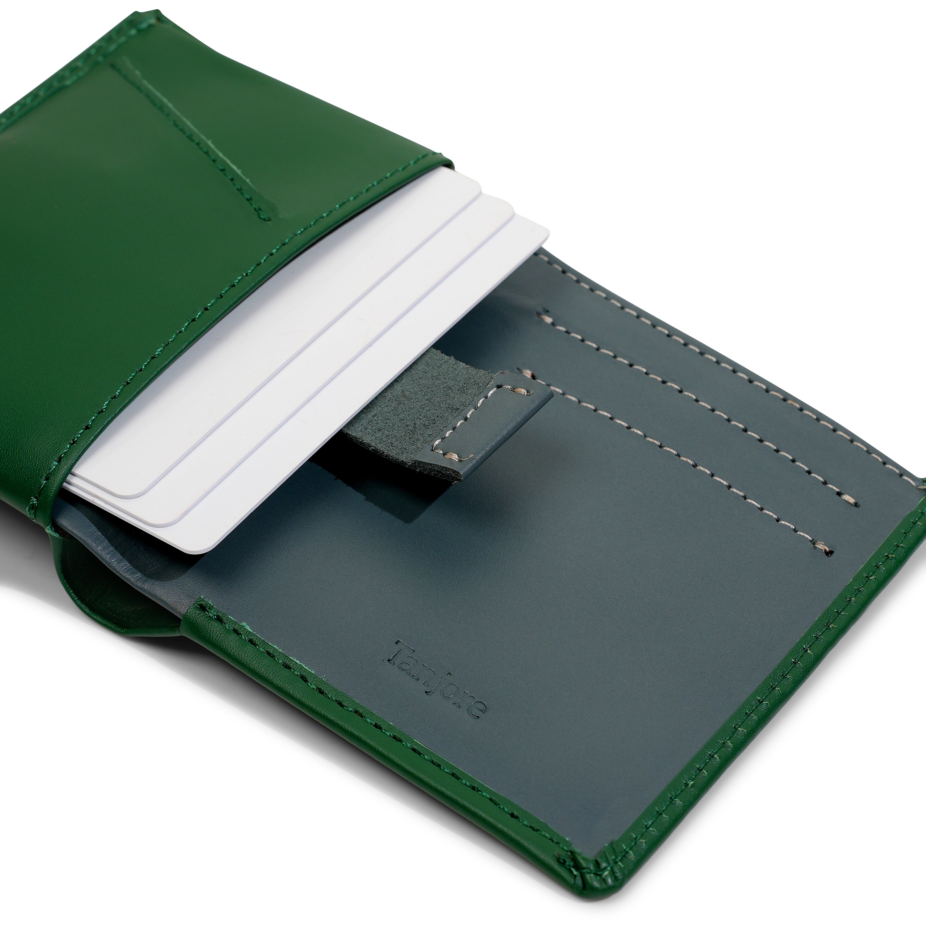 Close-up of the Pull Tab mechanism in the Tanjore Reserve Sleeve. Green leather exterior with Grey interior allows quick card access while maintaining a Slim Profile.