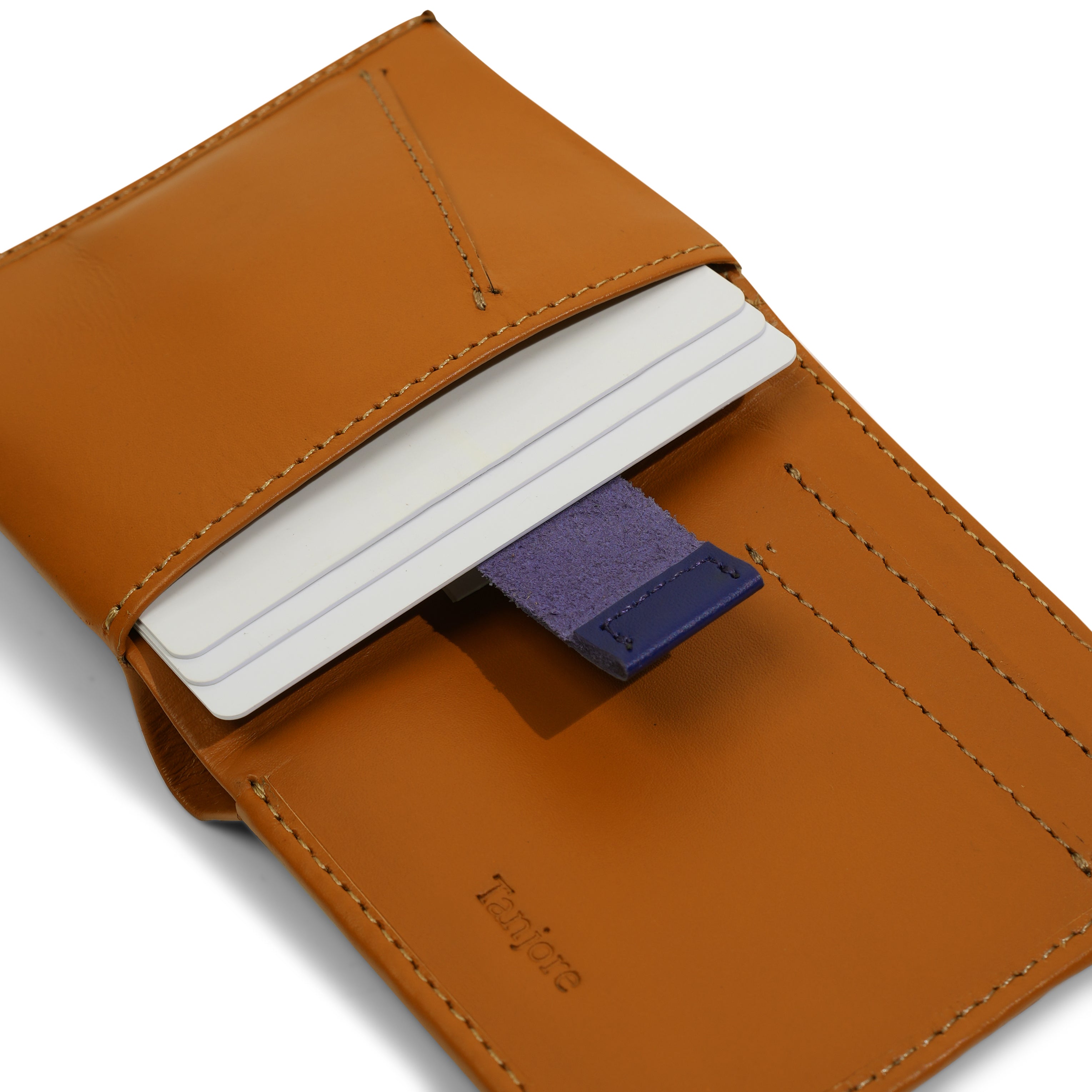 Close-up of the Blue Pull Tab mechanism in the Tanjore Reserve Sleeve. The Tan leather design allows quick card access while maintaining a Slim Profile.